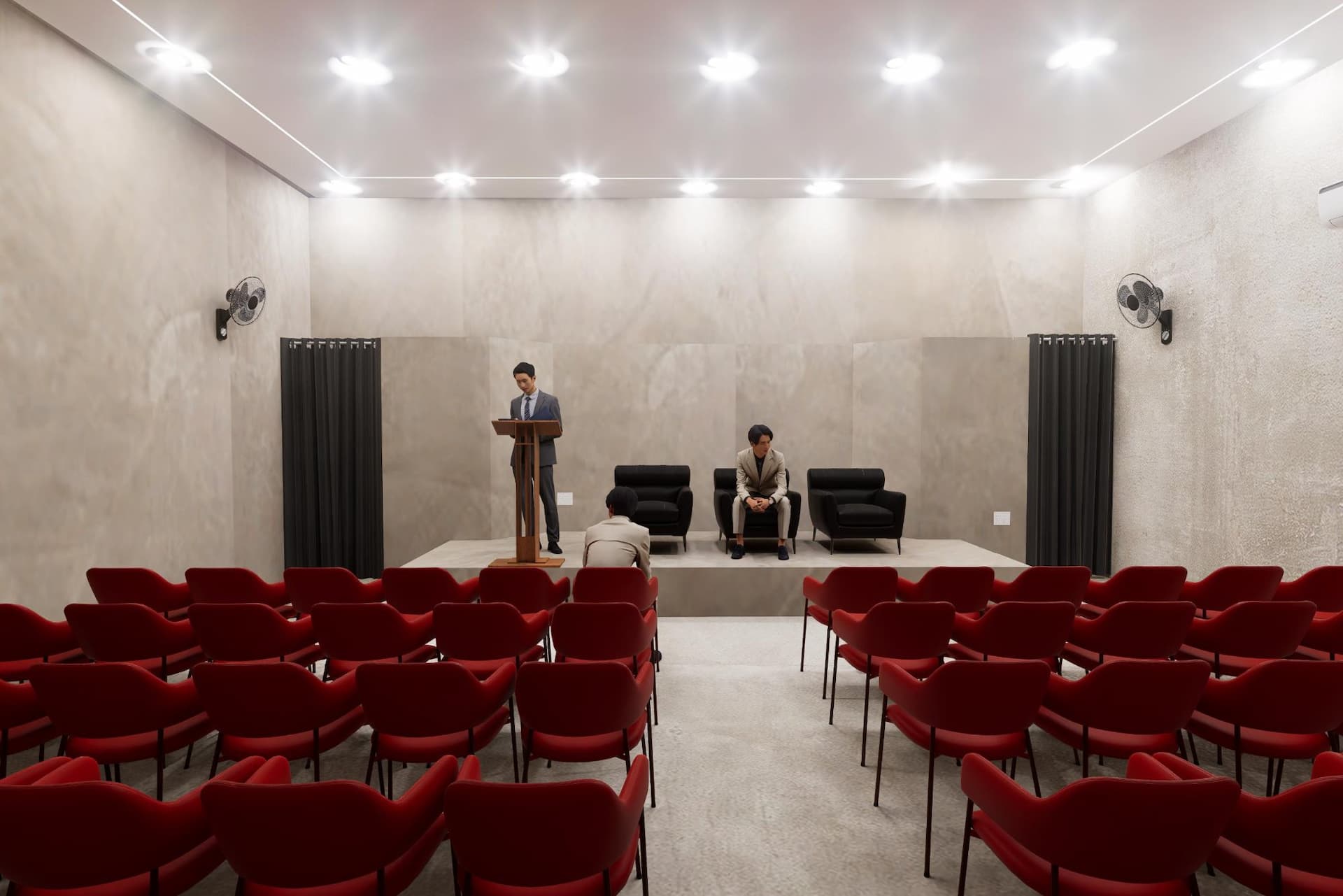 Inside the auditorium — red seating facing a low stage